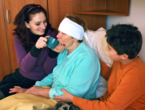 Caregiver assisting an old woman drinking water