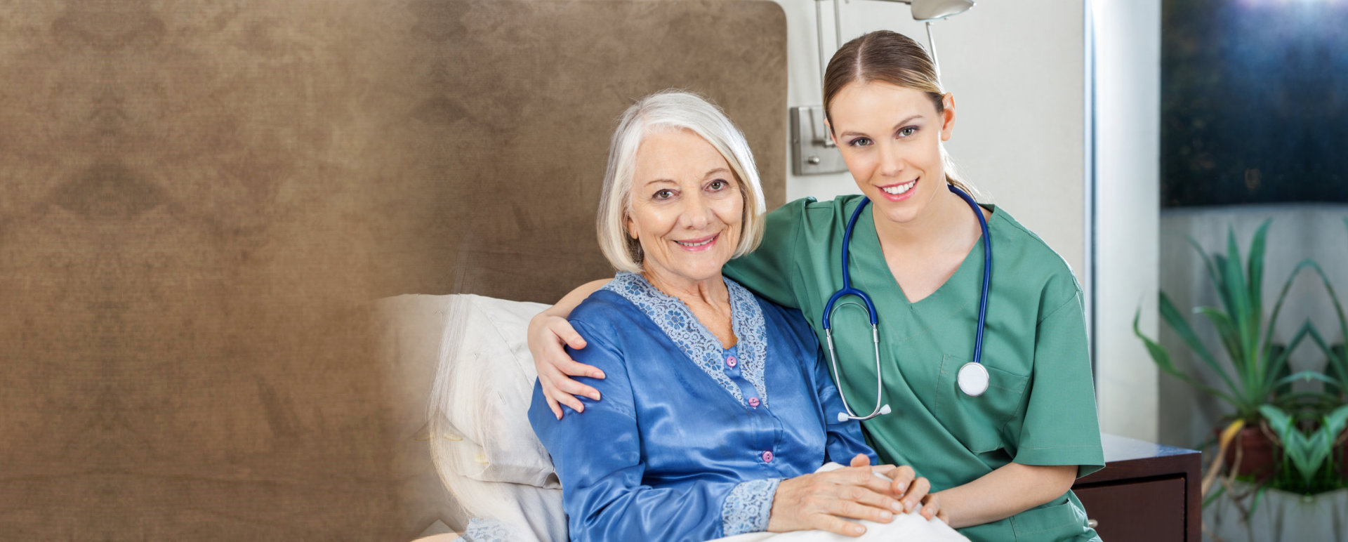 Portrait of happy female caretaker with arm around senior women at nursing home